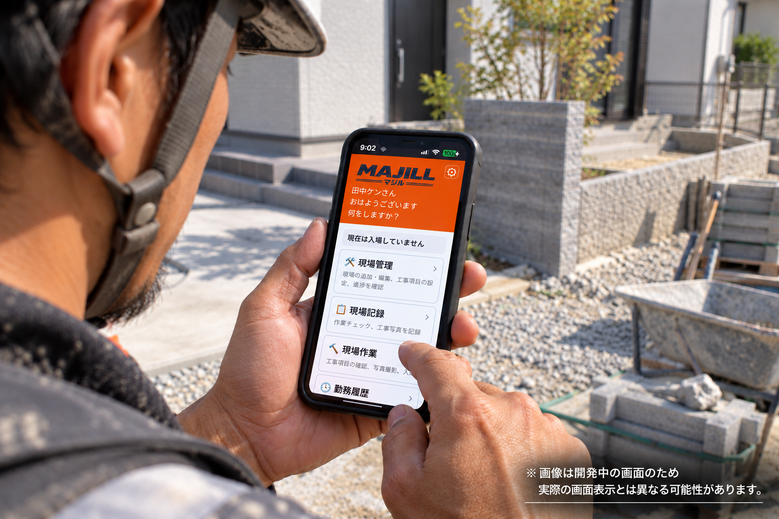 建設現場でMAJILLのホーム画面を確認する職人